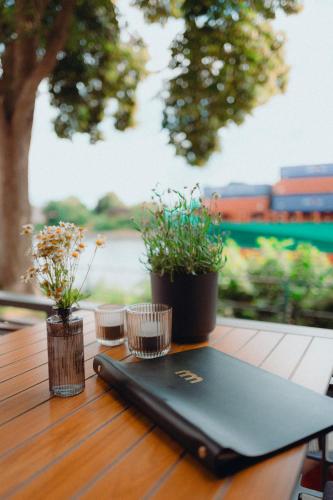a laptop sitting on top of a wooden table with plants at ConventGarten Hotel & Restaurant - am Nord-Ostsee-Kanal in Rendsburg