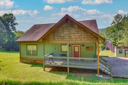 a small green house with a porch and an american flag at Hiawassee Cabin Near Lake Chatuge and AT Trailheads in Hiawassee