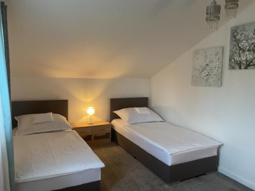 two beds in a room with a lamp on a table at Charming home near old town in Košice