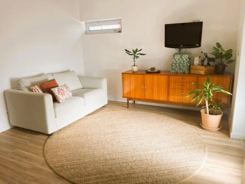 a living room with a white couch and a tv at Cortecasa, between the sea and nature in Cortegaça