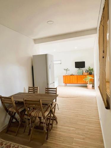 a dining room with a table and chairs and a refrigerator at Cortecasa, between the sea and nature in Cortegaça