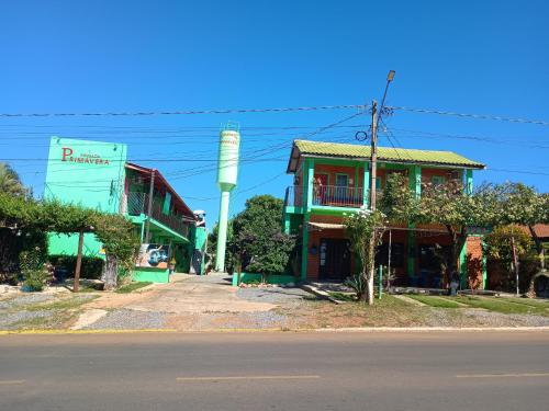 a building with a water tower next to a street at Pousada Primavera in Bonito