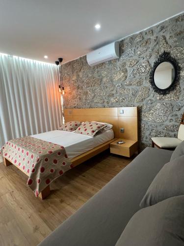 a bedroom with a bed and a mirror on the wall at Sequeira Arantes Casa 1 in Terras de Bouro