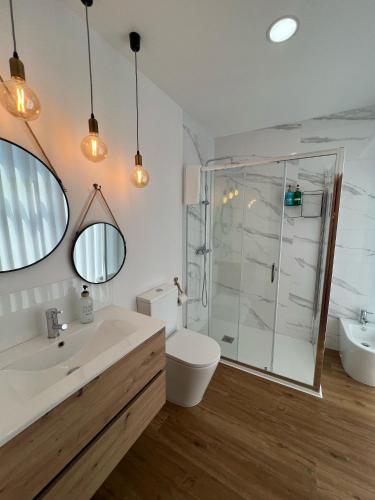a bathroom with a sink and a toilet and a shower at Sequeira Arantes Casa 1 in Terras de Bouro