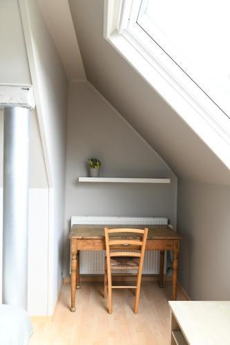 a wooden table with a chair in a room at Vakantiewoning Nijkenhof in Ninove