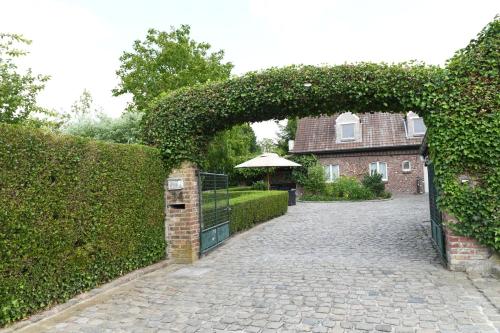 an entrance to a house with an ivy covered gate at Vakantiewoning Nijkenhof in Ninove