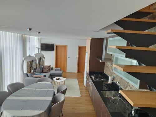 eine Küche und ein Wohnzimmer mit Tisch und Stühlen in der Unterkunft Sequeira Arantes Casa 1 in Terras de Bouro