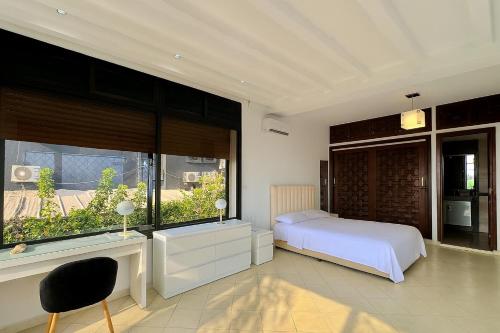 Un dormitorio con una cama y una ventana grande en Malabata Seaview Villa, en Tánger