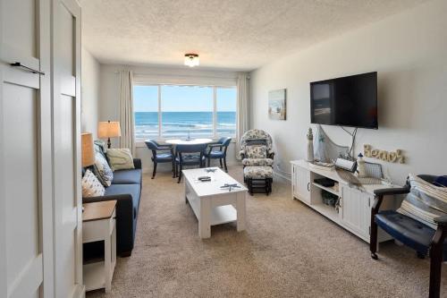 a living room with a couch and a table at Oceanfront Suite - Top Floor - Pool and Sauna - Sleeps 6 in Lincoln City