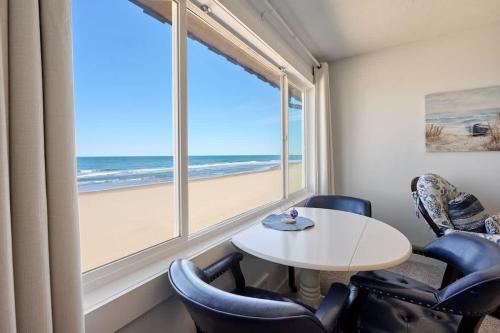 a room with a table and chairs and a large window at Oceanfront Suite - Top Floor - Pool and Sauna - Sleeps 6 in Lincoln City