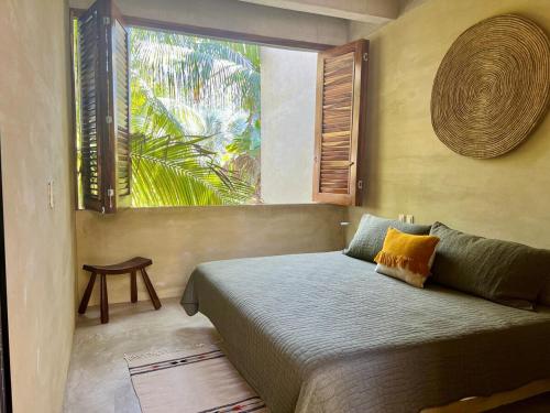 ein Schlafzimmer mit einem Bett und einem großen Fenster in der Unterkunft Casa Palmeras 2, Oasis House in Punta Zicatela in Brisas de Zicatela