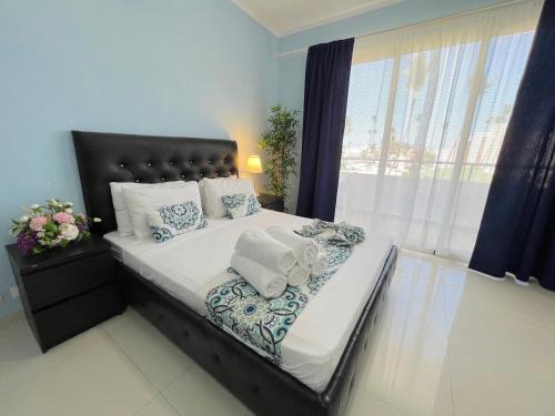 蓬塔卡纳DUCASSI DELUXE playa LOS CORALES - rooftop pool, restaurants and beach club的一间卧室，有一张大床，床上有毛巾