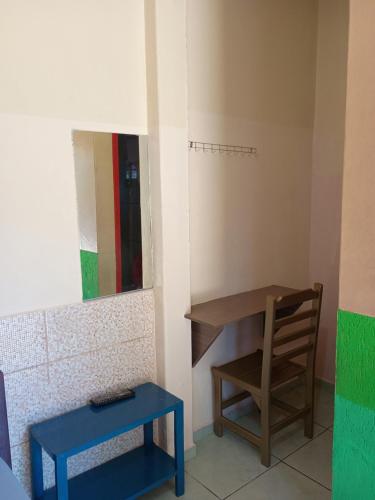 a room with a table and a chair and a mirror at Pousada Primavera in Bonito