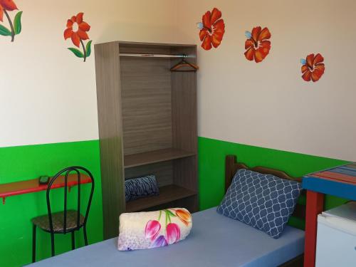 a room with a bed and a green wall at Pousada Primavera in Bonito