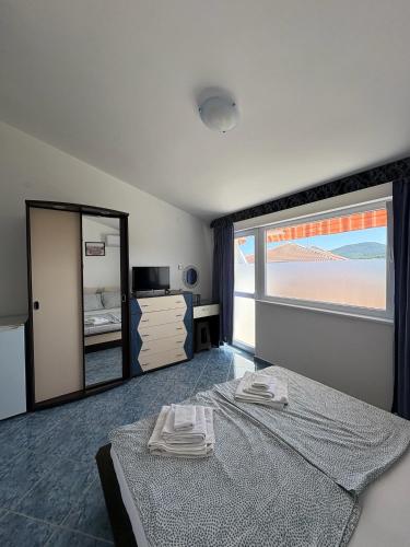 a bedroom with a bed and a large window at Sarievi Holiday Home in Tsarevo