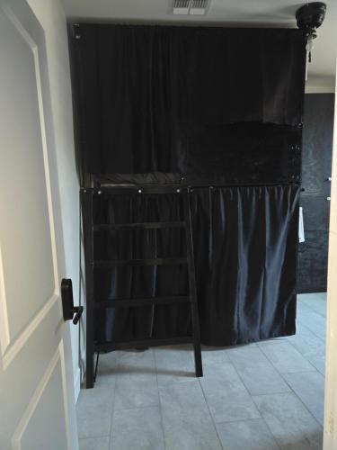 a black curtain in a room with a ladder at Casita in back house Not a hotel shared living in Glendale