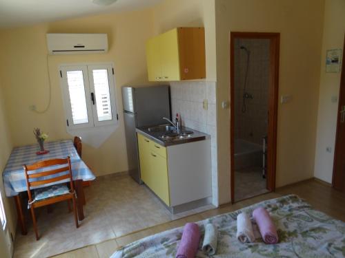 a small kitchen with a sink and a table at Apartments Jerković in Stari Grad