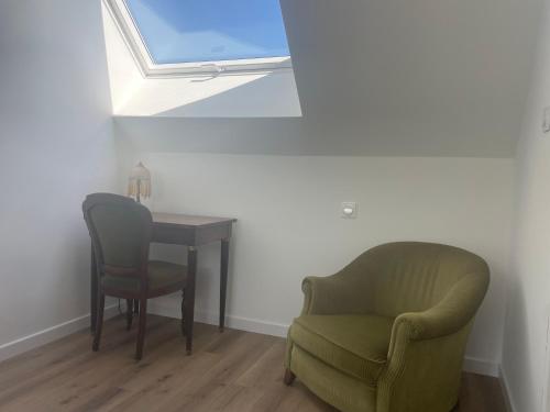 a room with a table and a chair and a window at Les vergers du Bunz in Lochrist