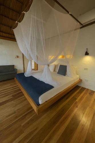 a bedroom with a bed with a mosquito net at RCH LUXURY HOTEL & POOL in Dibulla