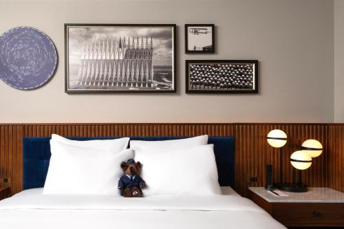 a teddy bear sitting on top of a bed at Hotel Polaris in Colorado Springs