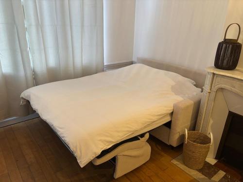 a small bed in a room next to a fireplace at Cozy studio en centre ville in Beauvais