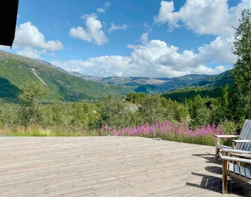 a bench sitting on a patio with mountains in the background at Stylish Cabin In Scenic Surroundings in Skare