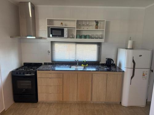 a kitchen with a white refrigerator and a stove at PLUM APART in San Rafael