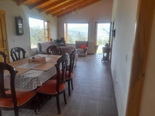 a dining room with a table and chairs at Refugio del Sauce Cabaña 1 Tibasosa- Boyacá in Tibasosa