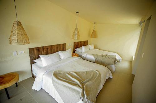 a bedroom with two beds and a table and two lamps at La Pausa Hotelbistro in Guatapé