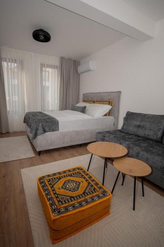 a bedroom with a bed and two tables and a couch at SARAJEVO SUITES No 23 Free parking in Sarajevo