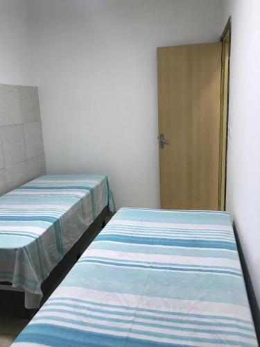 two beds in a room with a door at Casa Aconchego in Triunfo