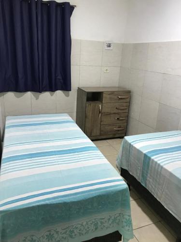 a bedroom with two beds and a dresser in it at Casa Aconchego in Triunfo