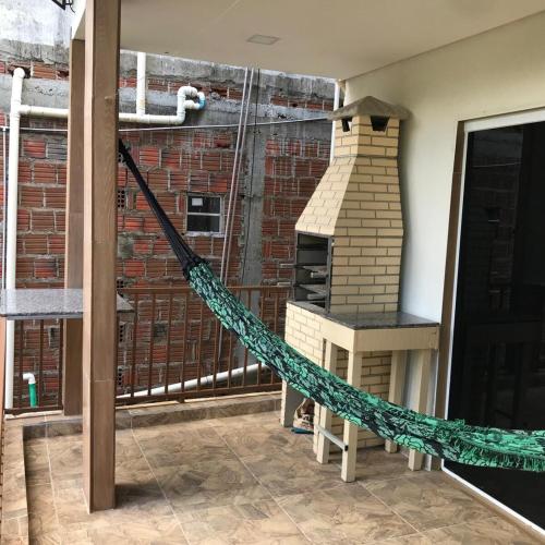 a hammock on a balcony with a brick oven at Casa Aconchego in Triunfo