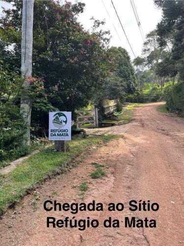 a dirt road with a sign on the side at Refúgio da Mata - Chalé Araucária in Paty do Alferes