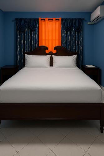 a bedroom with a large bed with an orange headboard at NesheLee Resorts in St Mary