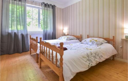 a bedroom with a wooden bed and a large window at Awesome Home In Colombieres With Wifi in Colombières