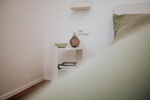 a room with a bed and a shelf with a clock at Auszeit in Halbturn in Halbturn
