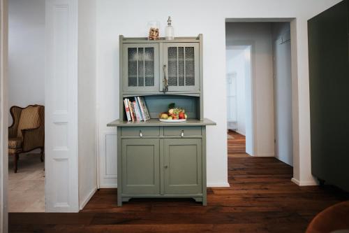 a green cabinet with a bowl of fruit in a hallway at Auszeit in Halbturn in Halbturn
