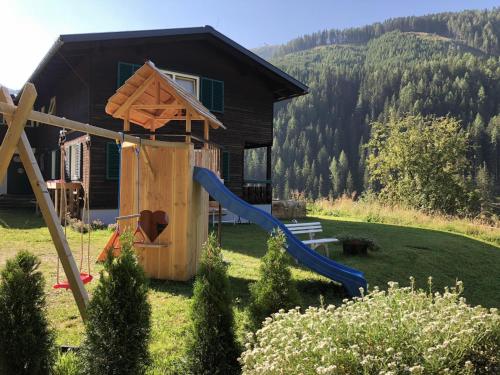 a playground in front of a house with a slide at Carmaliva in Innerkrems