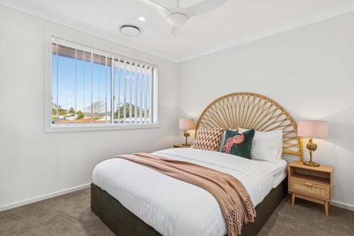 a bedroom with a large bed and a window at The Haven by Coast Hosting in Ettalong Beach