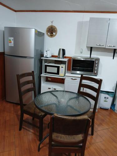 a kitchen with a table and chairs and a refrigerator at Apartamento 410 in Punta Arenas