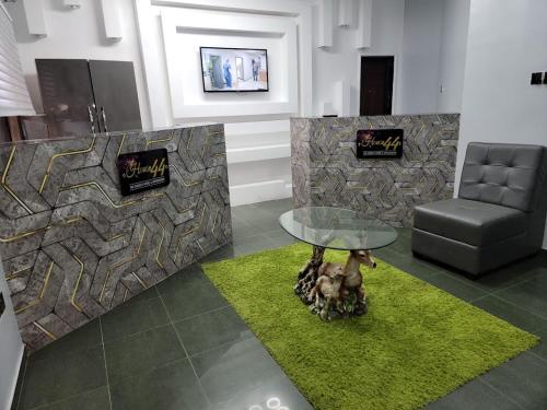 a living room with a table and a chair at Caesar's Hotel & Apartment Room #6 in Ikeja
