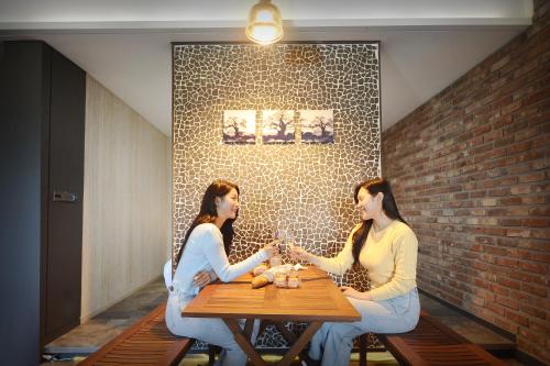 two women sitting at a table with wine glasses at K Boutique Hotel in Yeosu