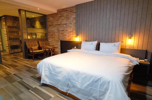a bedroom with a large white bed and a fireplace at K Boutique Hotel in Yeosu