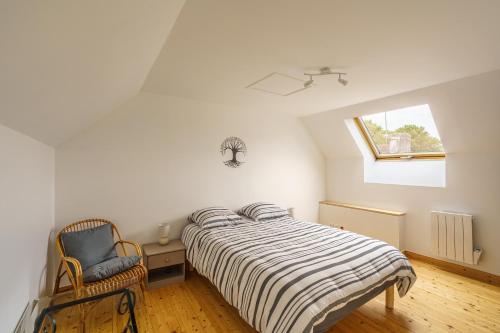Un dormitorio con una cama y una silla y una ventana. en Avel Mor - Proche de Quimper, en Pluguffan