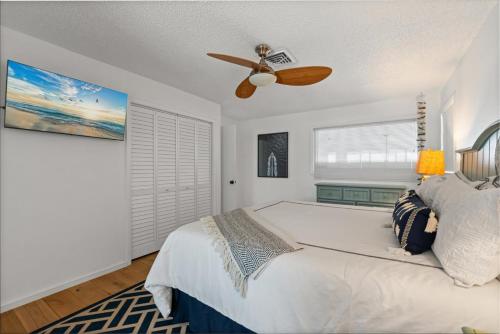 a bedroom with a bed with a ceiling fan at Private Bayfront Beach House with Dock, Steps to Beach and Restaurants in Englewood
