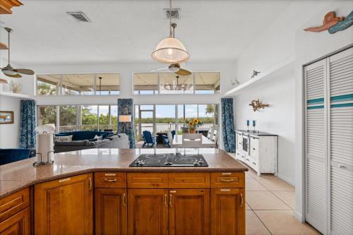 a kitchen and living room with a stove top oven at Private Bayfront Beach House with Dock, Steps to Beach and Restaurants in Englewood