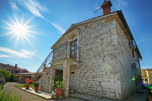 a building with a balcony and the sun in the sky at Apartment in Baderna - Istrien 44223 in Baderna