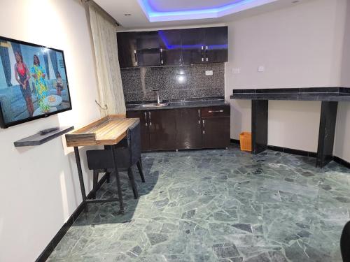 eine Küche mit Theke und Tisch in einem Raum in der Unterkunft Super Deluxe Room #1 in Ikeja