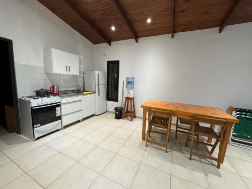 a kitchen with a wooden table and a table and chairs at Cabaña YMBYATY in Colonia Carlos Pellegrini